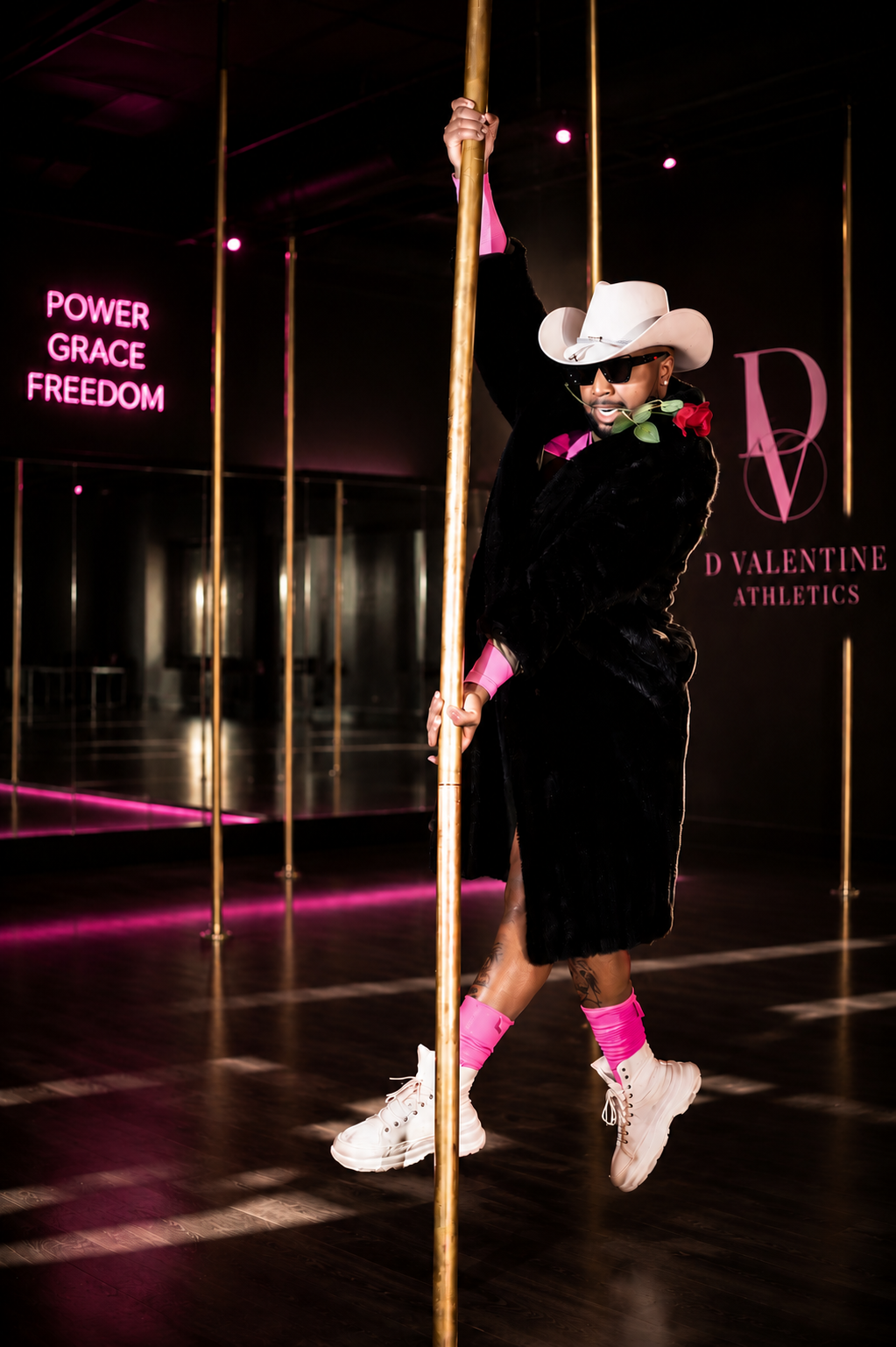 Dior on the pole in a black fur coat and white cowboy hat at D Valentine Athletics studio